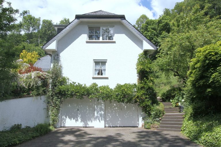 Süd-Ansicht mit Garagen, rechts Treppe zum Eingang - EIFEL MAKLER